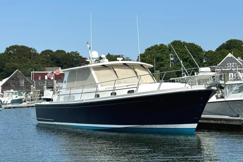 Slide: The Image of 2009 Grand Banks 45 Eastbay SX yacht docked in a marina, surrounded by other boats. - 1