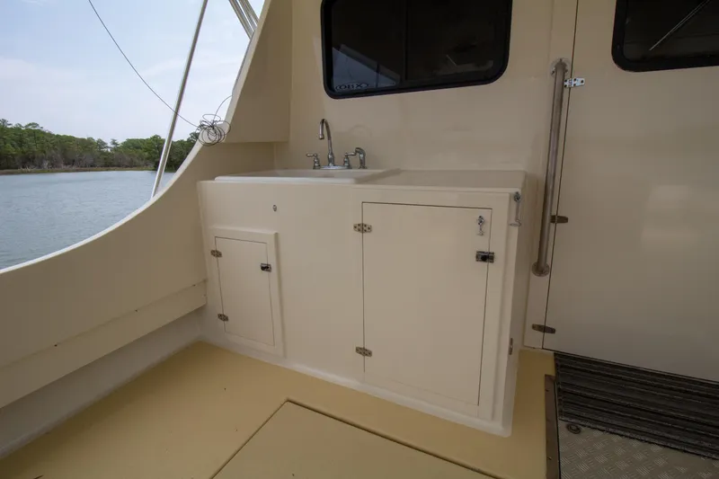 Slide: The Image of Chesapeake 48 Deadrise 2008 boat interior with sink and storage cabinets. - 21