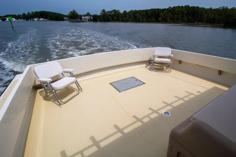 Slide: The Image of Chesapeake 48 Deadrise 2008 boat deck with chairs, cruising on a calm river. - 26