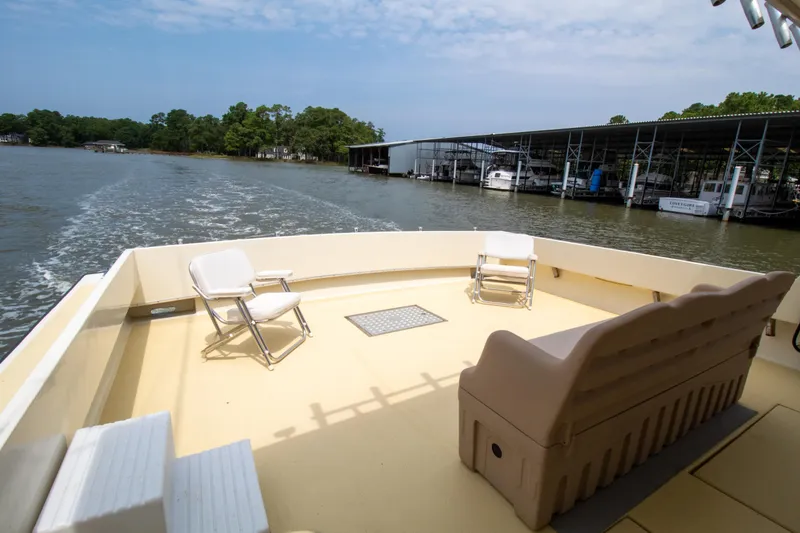 Slide: The Image of 2008 Chesapeake 48 Deadrise boat deck with chairs, cruising near marina. - 27