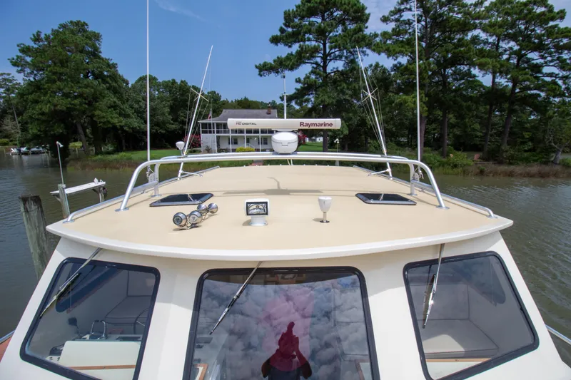 Slide: The Image of 2008 Chesapeake 48 Deadrise boat with Raymarine equipment, docked near lush greenery. - 33