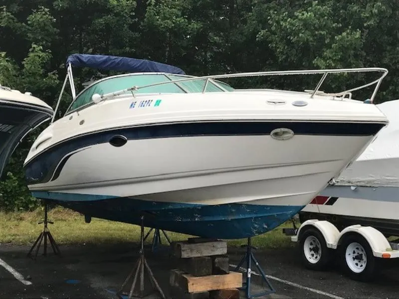 Slide: The Image of 2001 Chaparral 235 SSi boat on stands, with blue accents, in a wooded area. - 7