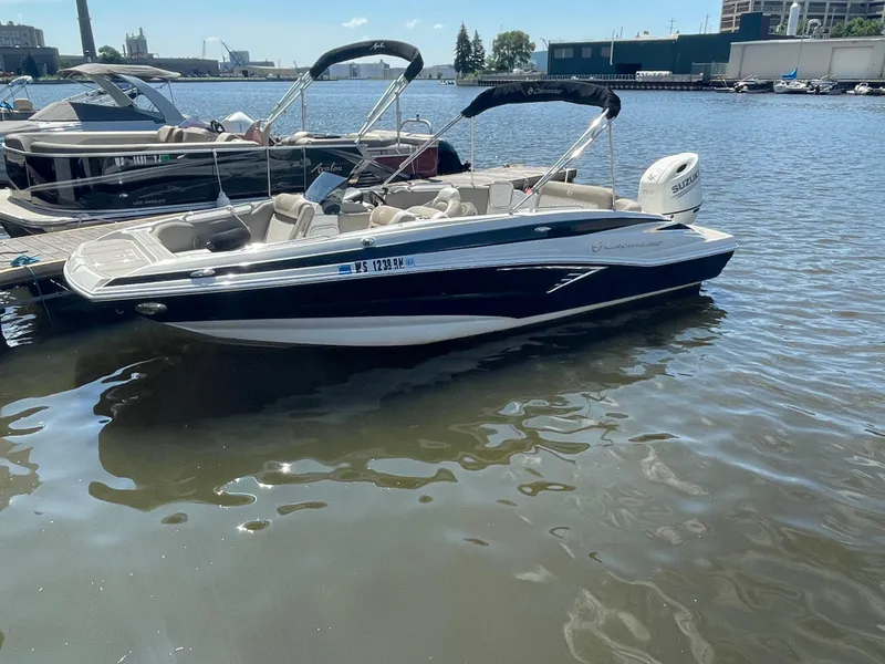 Slide: The Image of 2020 Crownline E 205 XS boat docked on calm water. - 1