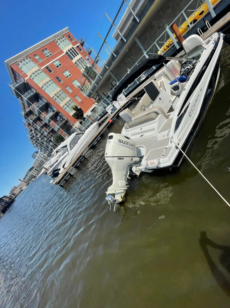 Slide: The Image of 2020 Crownline E 205 XS boat docked near waterfront buildings. - 11