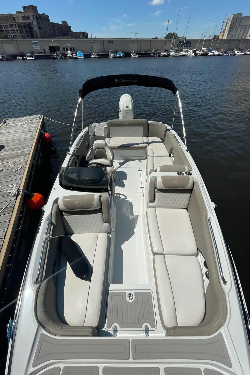 Slide: The Image of 2020 Crownline E 205 XS boat docked at marina, featuring spacious seating and sleek design. - 13