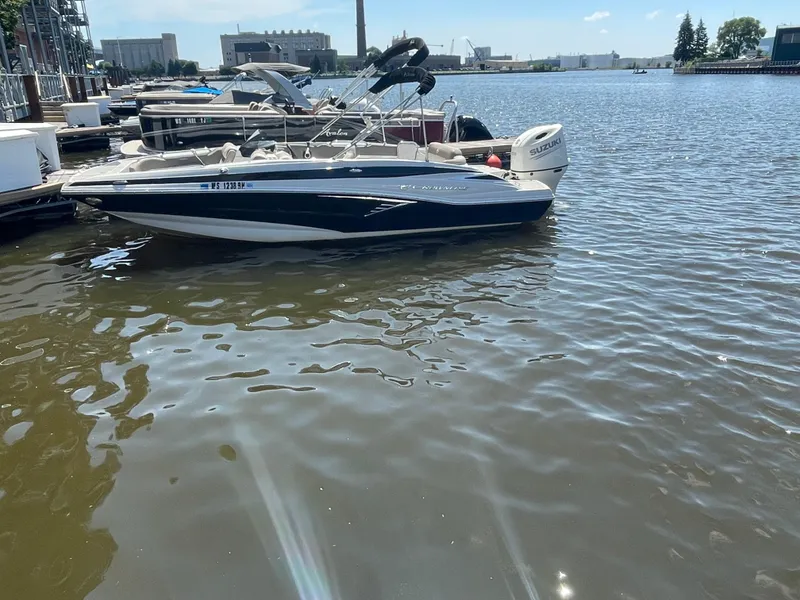 Slide: The Image of 2020 Crownline E 205 XS boat docked on a sunny waterfront. - 4