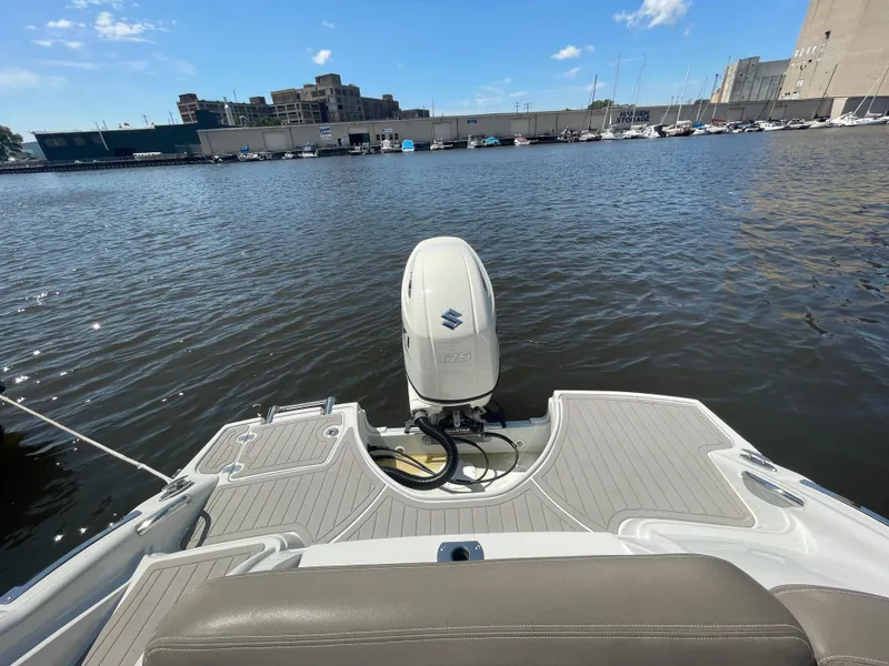 Slide: The Image of 2020 Crownline E 205 XS boat with Suzuki outboard motor on a calm waterfront. - 9