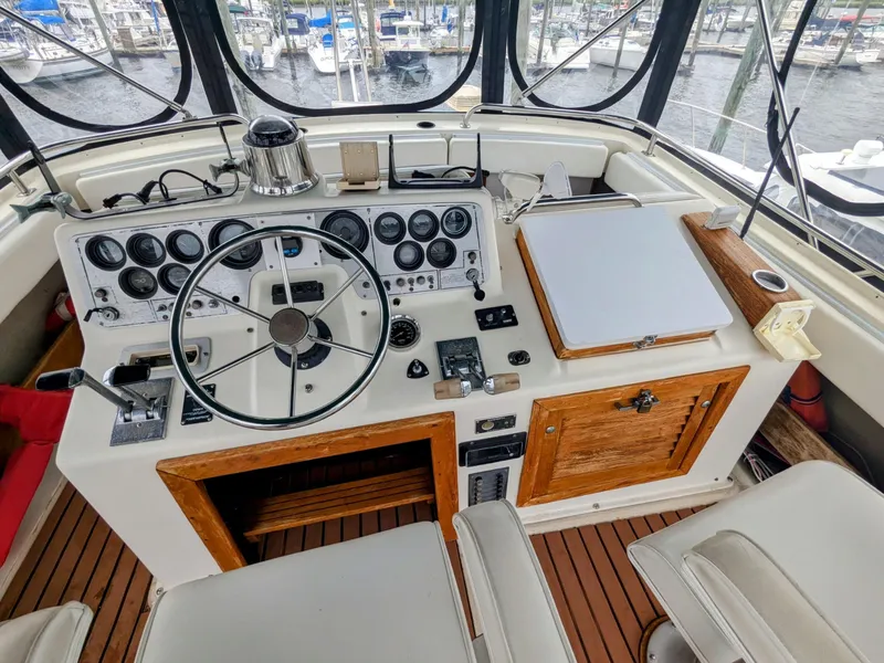 Slide: The Image of 1981 Silverton 37 Convertible helm with gauges, steering wheel, and wooden accents. - 12