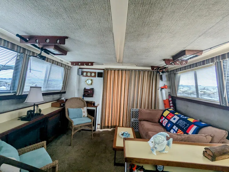 Slide: The Image of Interior of a 1981 Silverton 37 Convertible boat with cozy seating and nautical decor. - 16