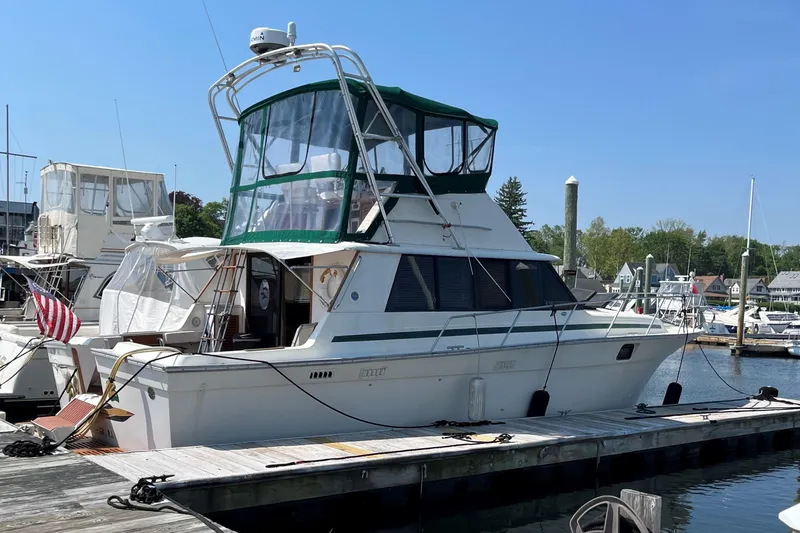 Slide: The Image of 1981 Silverton 37 Convertible yacht docked at marina under clear blue sky. - 2