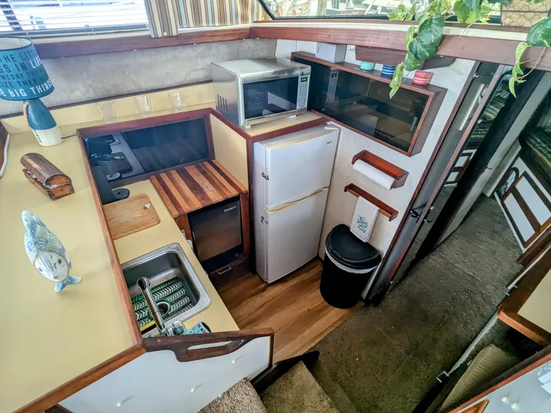 Slide: The Image of 1981 Silverton 37 Convertible boat kitchen with fridge, microwave, and sink. - 23