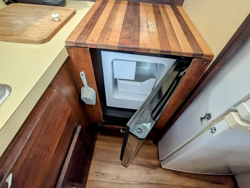 Slide: The Image of 1981 Silverton 37 Convertible kitchen with open mini fridge and wooden countertop. - 27