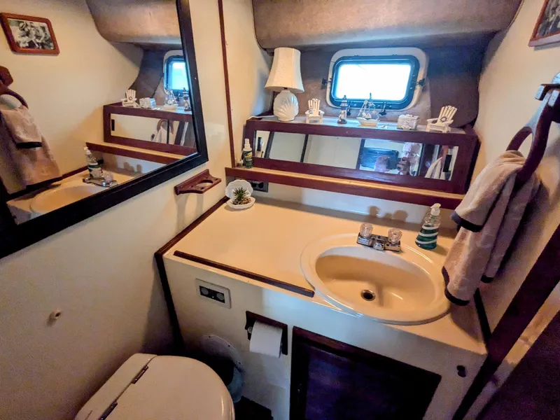 Slide: The Image of 1981 Silverton 37 Convertible bathroom with sink, mirror, and nautical decor. - 28