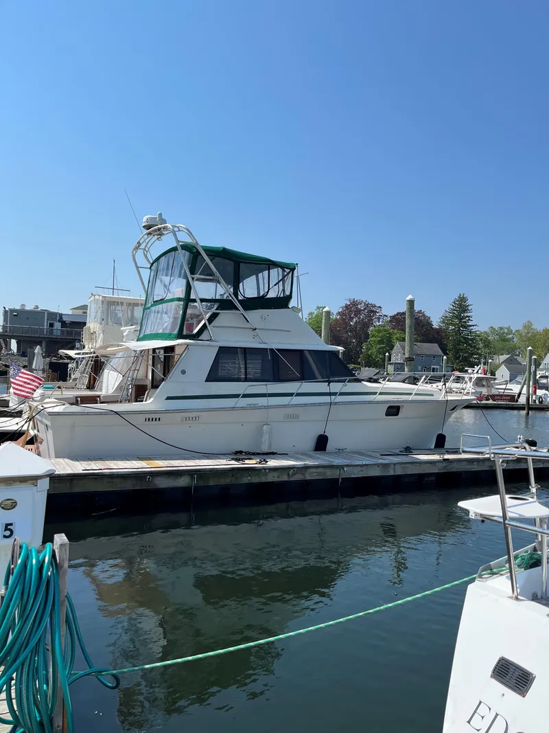 Slide: The Image of 1981 Silverton 37 Convertible yacht docked at marina under clear blue sky. - 3