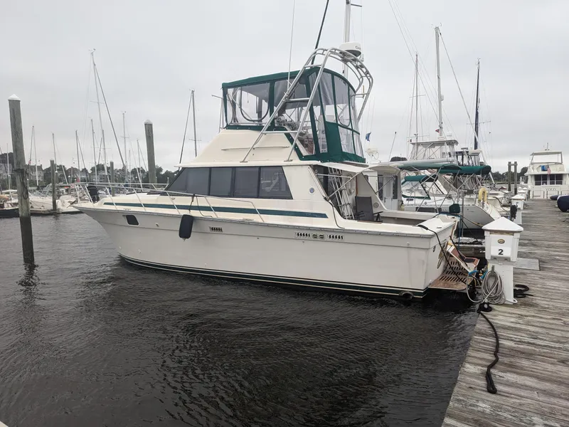 Slide: The Image of 1981 Silverton 37 Convertible boat docked at marina, featuring green canopy and classic design. - 5