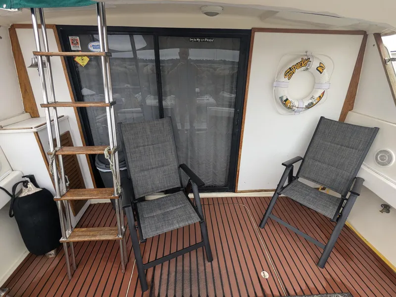 Slide: The Image of 1981 Silverton 37 Convertible boat deck with chairs, ladder, and life preserver. - 9