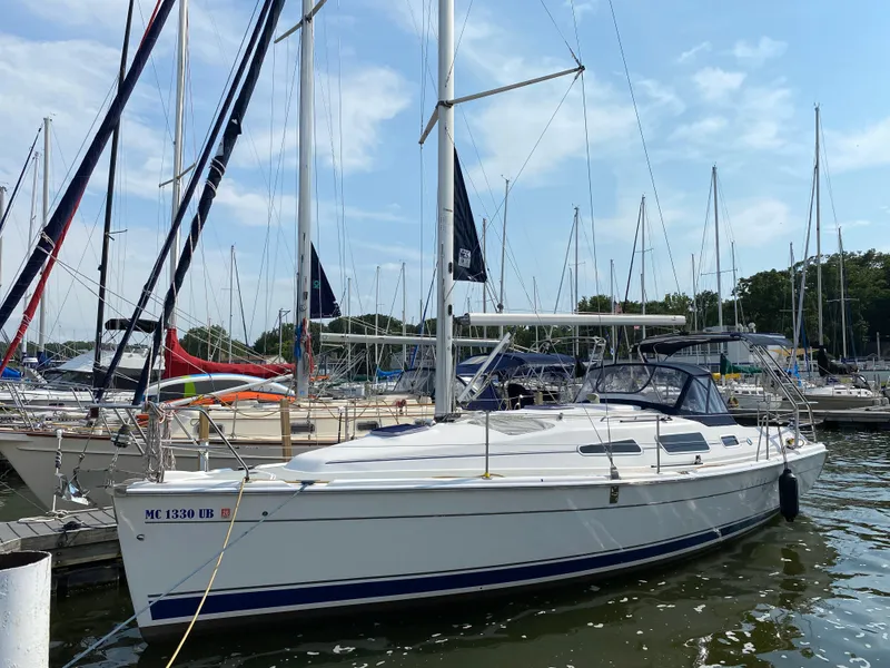 The Image of 2008 Hunter 33 sailboat docked in a marina, surrounded by other sailboats. - 0