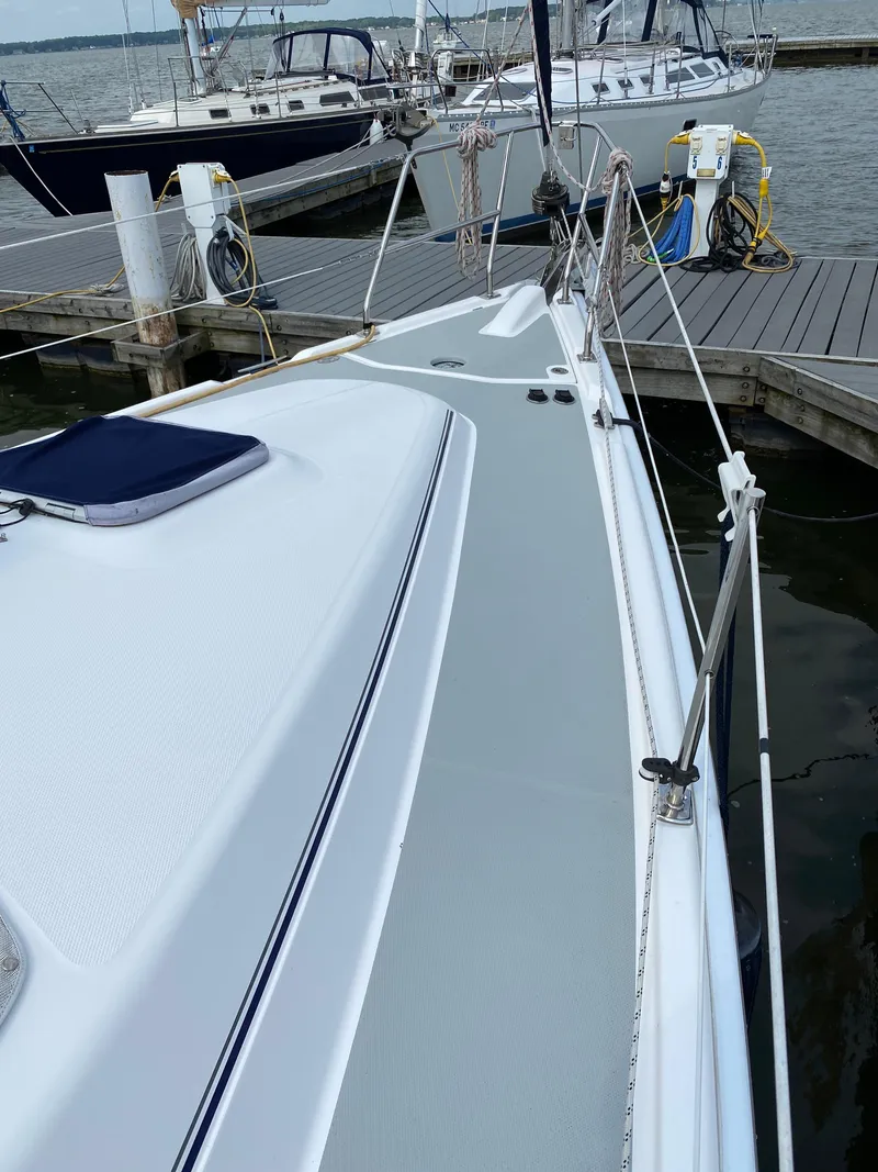 Slide: The Image of 2008 Hunter 33 sailboat docked at marina, showing deck and railing. - 13
