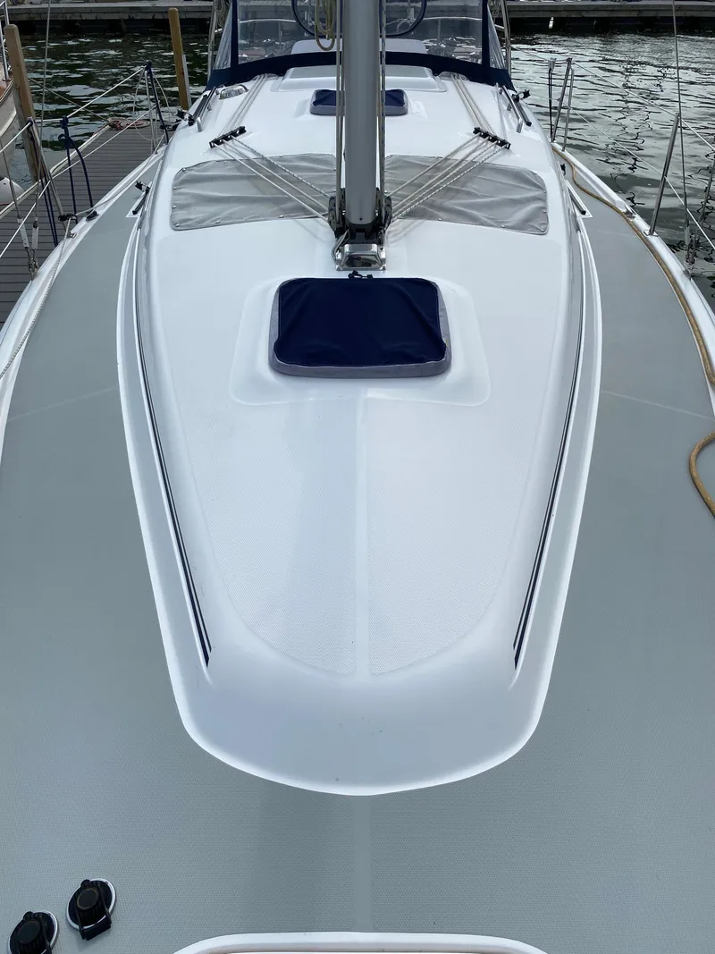 Slide: The Image of 2008 Hunter 33 sailboat deck with mast and hatch, docked by the water. - 19