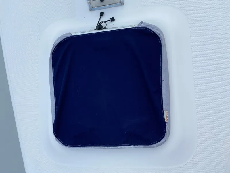 Slide: The Image of Hatch cover on a 2008 Hunter 33 sailboat, featuring a dark blue fabric. - 23