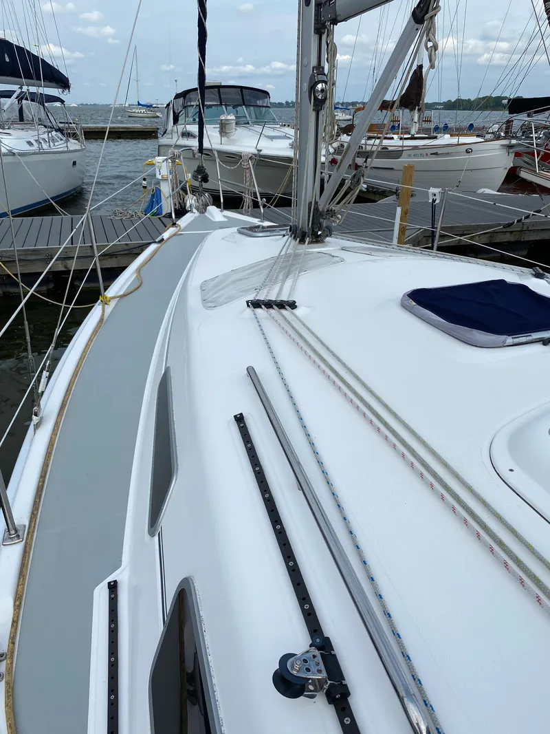 Slide: The Image of 2008 Hunter 33 sailboat docked at marina, showcasing deck and rigging. - 26