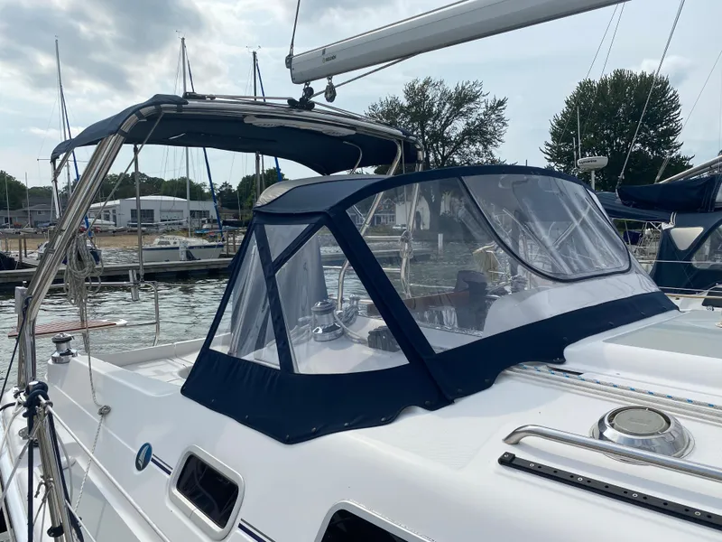 Slide: The Image of 2008 Hunter 33 sailboat docked at marina with blue canopy and clear enclosure. - 32