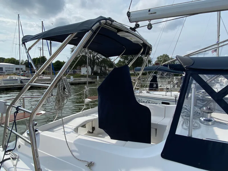 Slide: The Image of 2008 Hunter 33 sailboat with blue canopy docked at marina. - 34