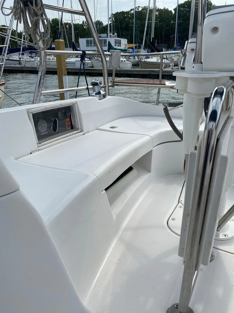 Slide: The Image of 2008 Hunter 33 sailboat cockpit with white seating and marina background. - 48