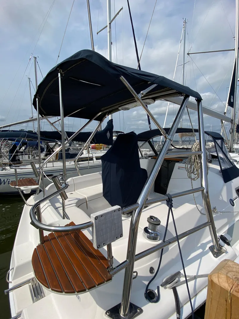 Slide: The Image of 2008 Hunter 33 sailboat cockpit with canopy, stainless steel railings, and wooden steps. - 6