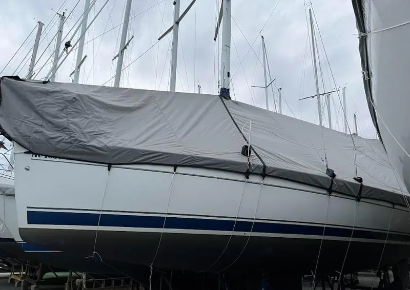 Slide: The Image of 2008 Hunter 33 sailboat covered with a protective tarp, docked in a marina. - 8