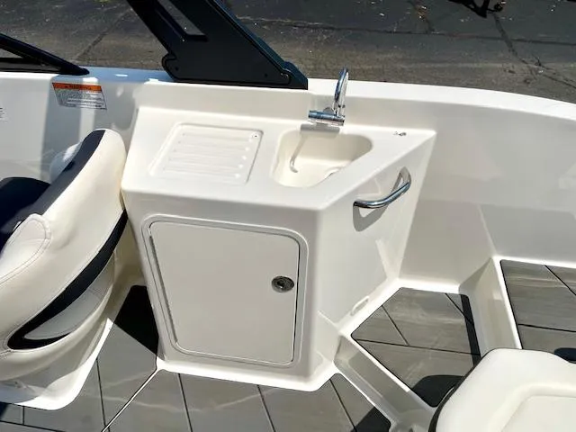 Slide: The Image of 2021 Bayliner DX 2250 boat interior with sink and storage compartment. - 18