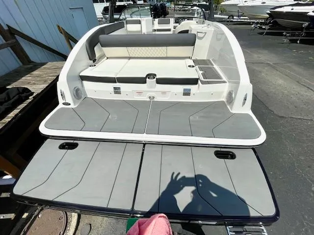 Slide: The Image of 2021 Bayliner DX 2250 boat with spacious seating and swim platform in a marina setting. - 5