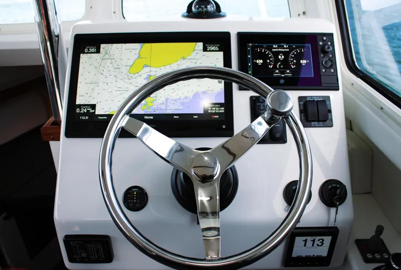 Slide: The Image of Steering console of 2022 Ocean Sport 30 Roamer, featuring navigation screens and controls. - 10