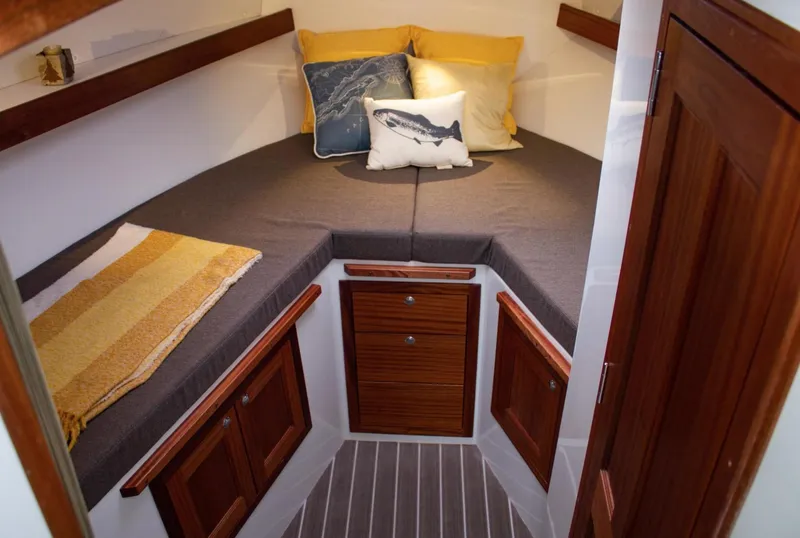 Slide: The Image of Cozy cabin interior of 2022 Ocean Sport 30 Roamer with wood accents and cushions. - 18