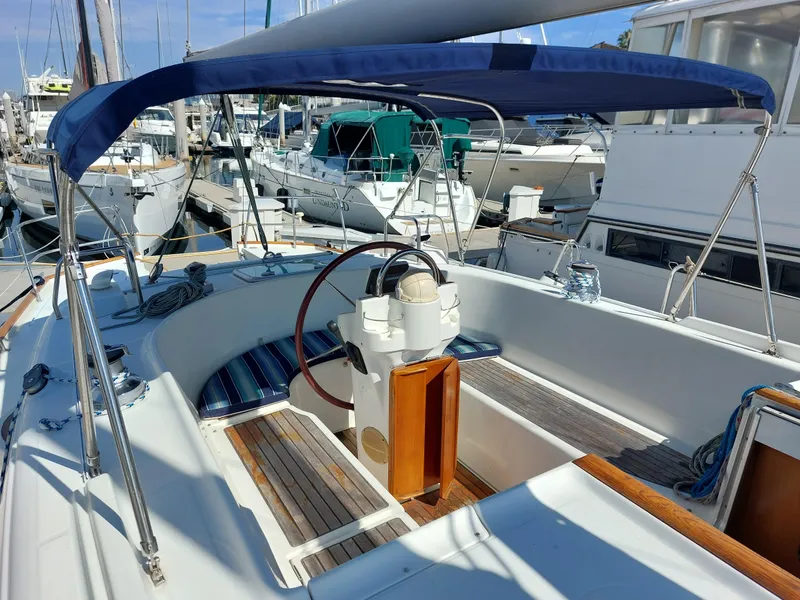 Slide: The Image of 2002 Beneteau Oceanis 42CC sailboat cockpit with blue canopy and wooden accents. - 22