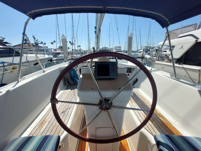 Slide: The Image of Beneteau Oceanis 42CC cockpit with steering wheel, docked in marina, 2002 model. - 26