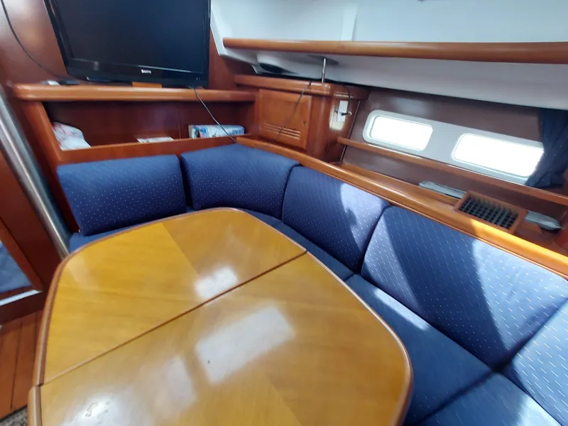 Slide: The Image of Interior of 2002 Beneteau Oceanis 42CC yacht with blue seating and wooden table. - 38