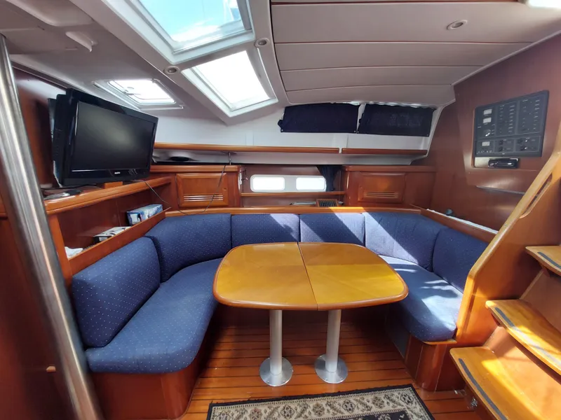 Slide: The Image of Interior of 2002 Beneteau Oceanis 42CC yacht with cozy seating and wooden table. - 39
