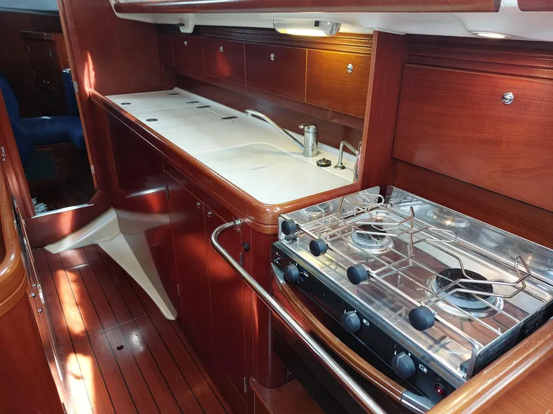 Slide: The Image of Beneteau Oceanis 42CC 2002 yacht kitchen with stove and wooden cabinetry. - 43