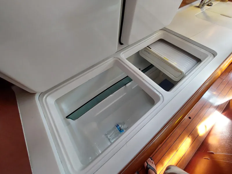 Slide: The Image of Beneteau Oceanis 42CC 2002 yacht interior storage compartments on wooden floor. - 48