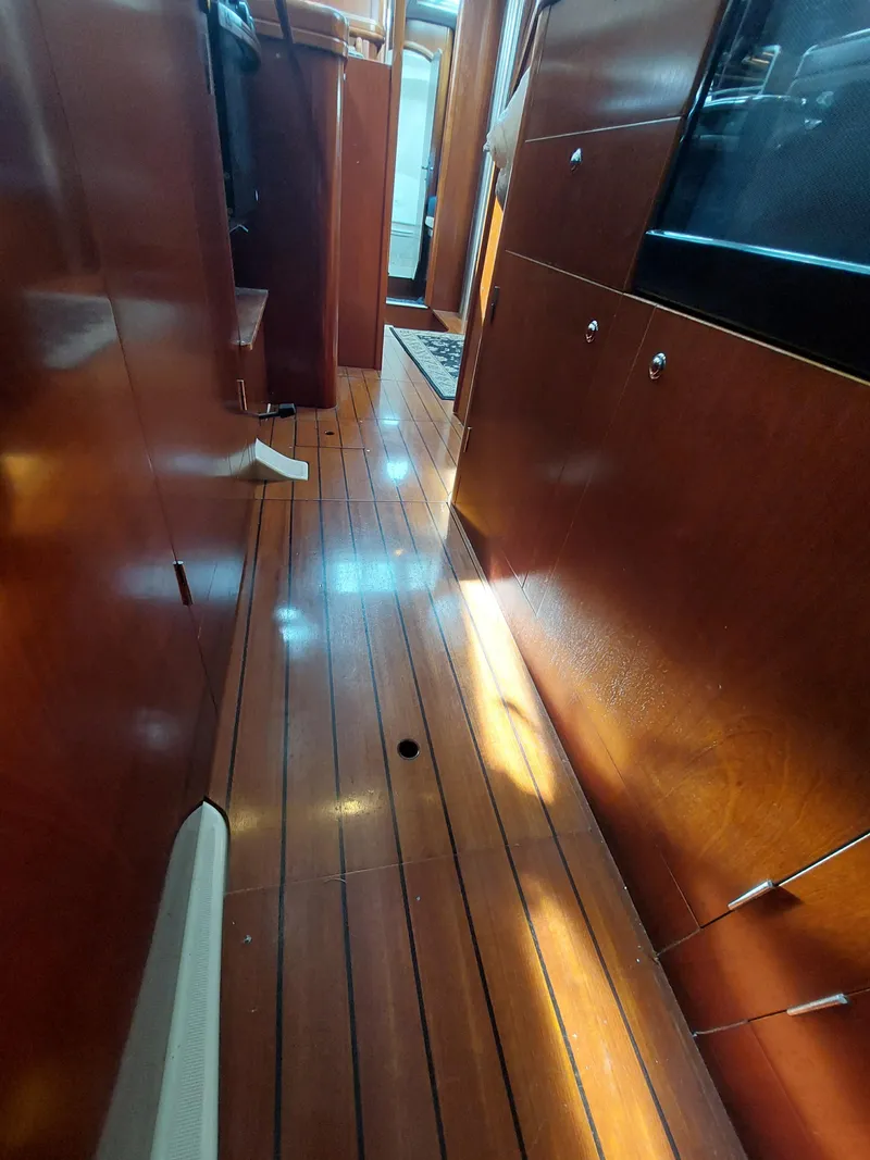 Slide: The Image of Interior view of 2002 Beneteau Oceanis 42CC sailboat with polished wooden flooring. - 49