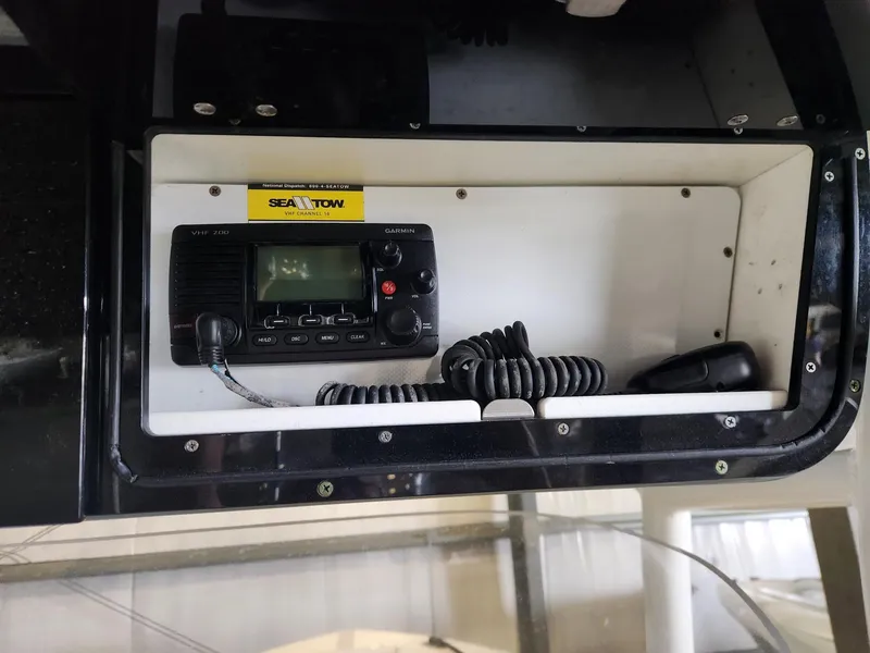 Slide: The Image of 2016 Key West 281 Billistic boat radio compartment with Sea Tow sticker and communication device. - 17