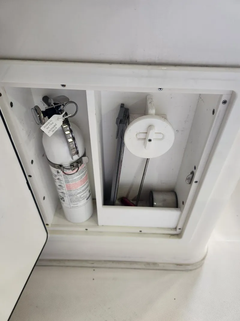 Slide: The Image of 2016 Key West 281 Billistic boat compartment with fire extinguisher and tools. - 26