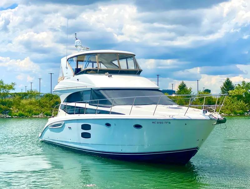 Slide: The Image of 2014 Meridian 441 Sedan yacht on a serene lake under a cloudy sky. - 2
