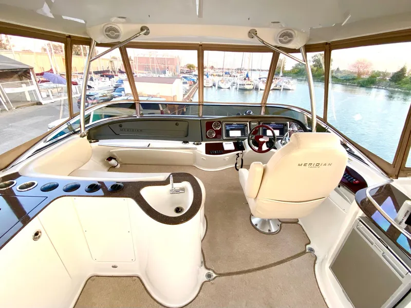 Slide: The Image of 2014 Meridian 441 Sedan yacht cockpit with modern controls and panoramic marina view. - 17