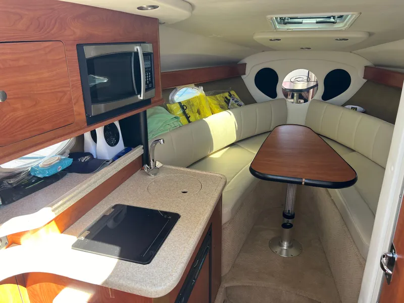 Slide: The Image of Interior of 2008 Rinker 260 Express Cruiser with kitchenette and seating area. - 15