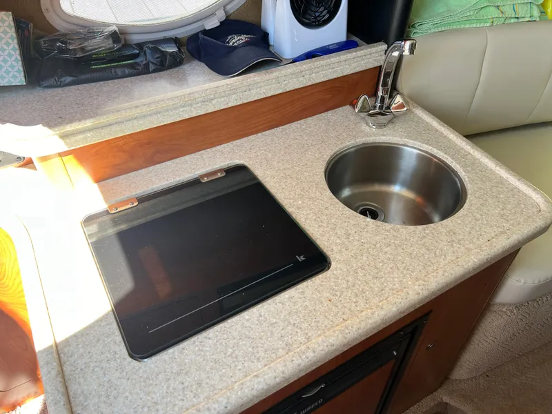 Slide: The Image of Compact kitchenette in 2008 Rinker 260 Express Cruiser with sink and stove. - 17