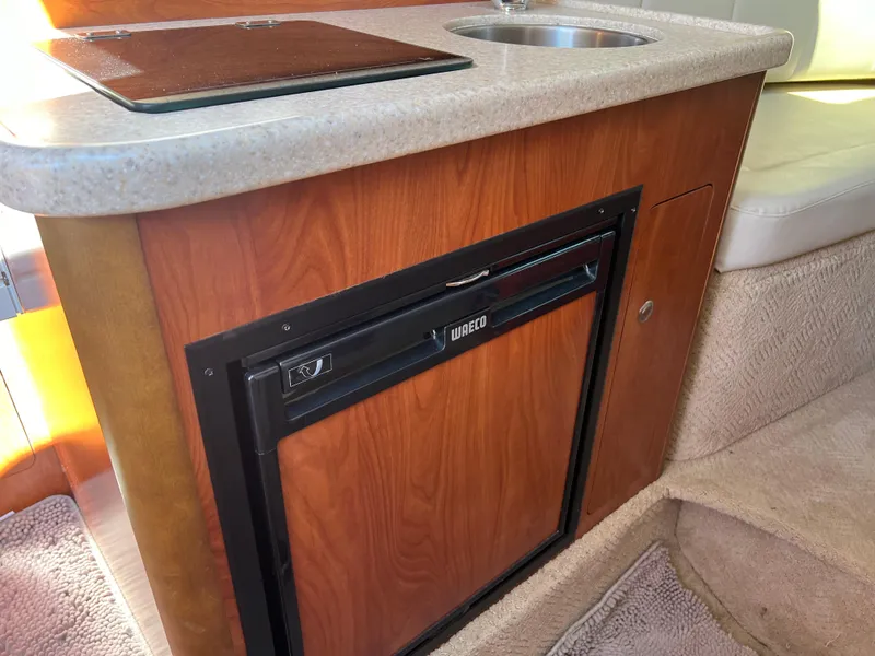 Slide: The Image of 2008 Rinker 260 Express Cruiser interior with kitchenette and mini fridge. - 18