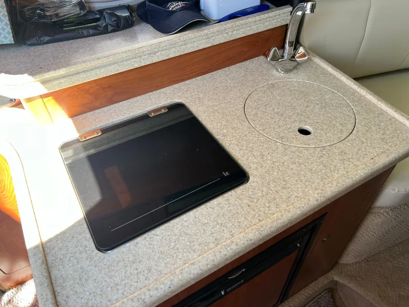 Slide: The Image of 2008 Rinker 260 Express Cruiser kitchenette with sink and stove. - 19