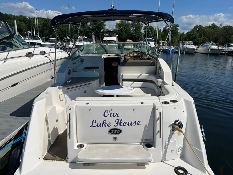 Slide: The Image of 2008 Rinker 260 Express Cruiser docked, named "Our Lake House," with spacious seating. - 2